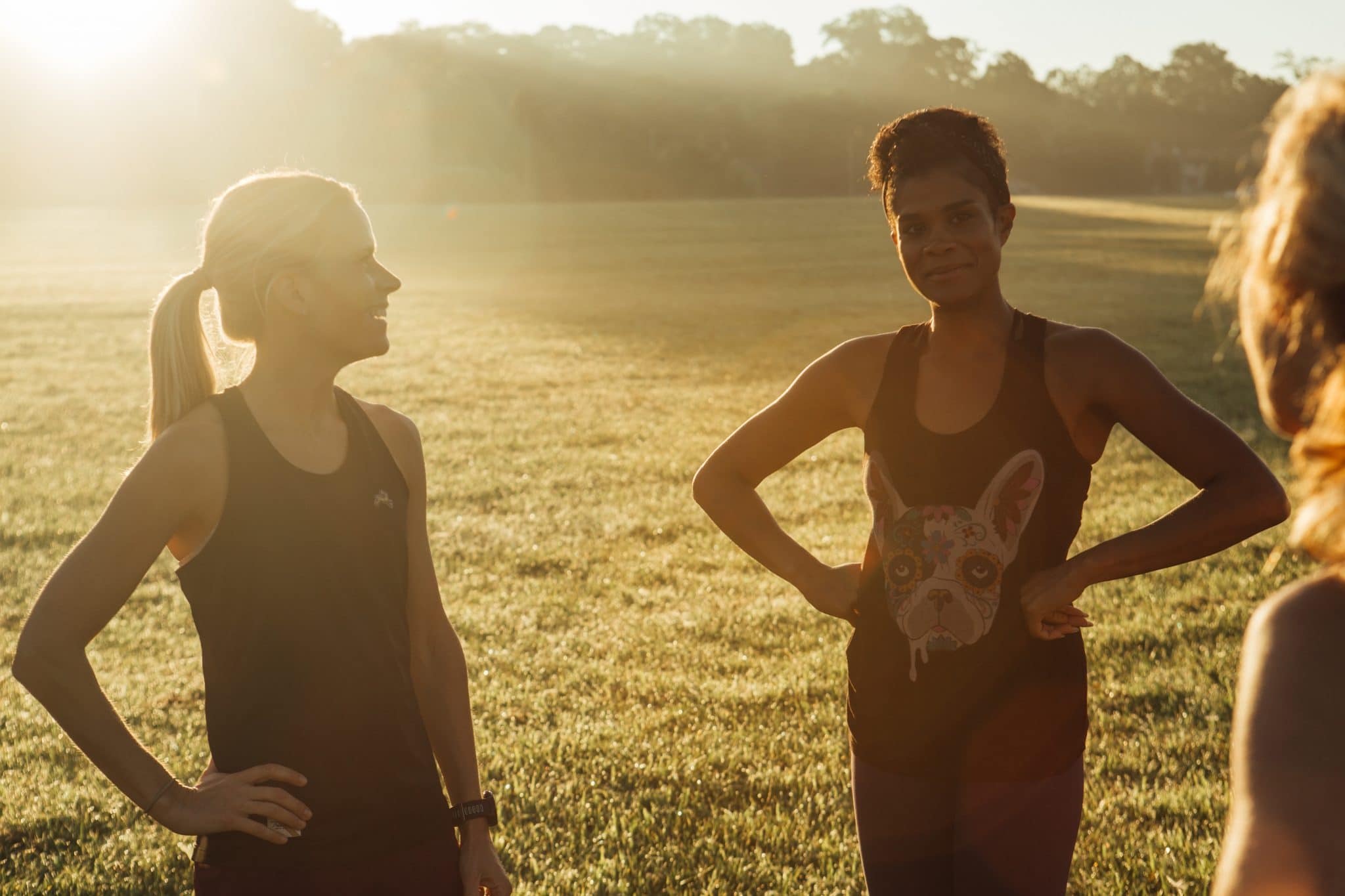 women in a field talking in running clothes