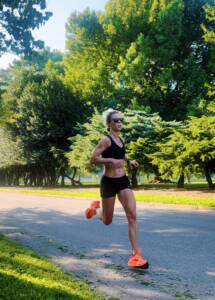 Whitney Heins running on Road in black and orange