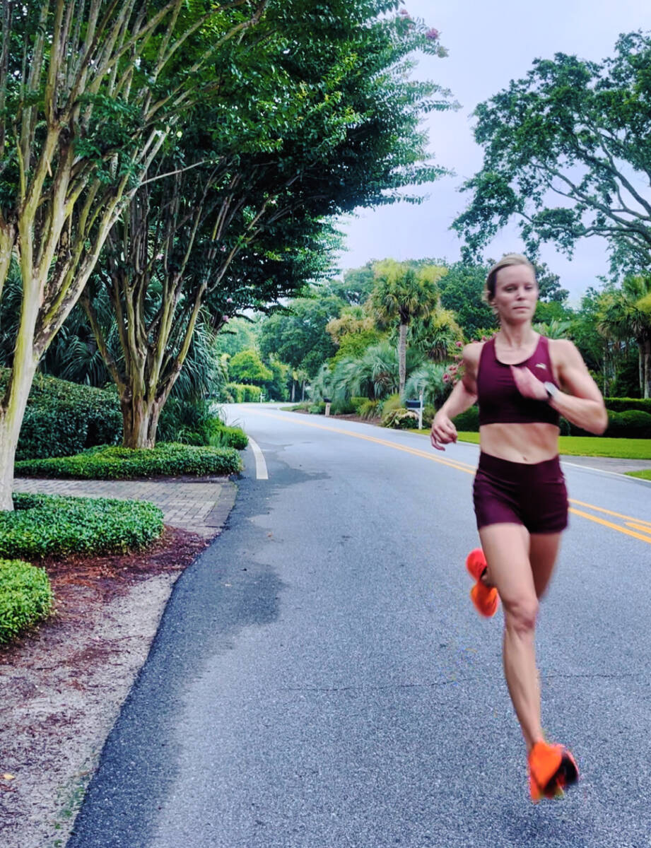 Whitney Heins running in red track smith outfit