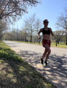 woman running in black sports bra and red shorts