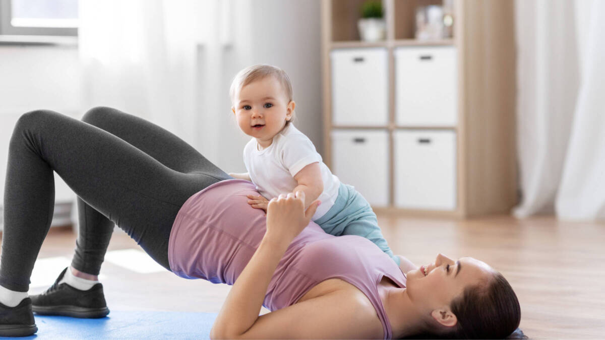 woman doing a bridge with a baby