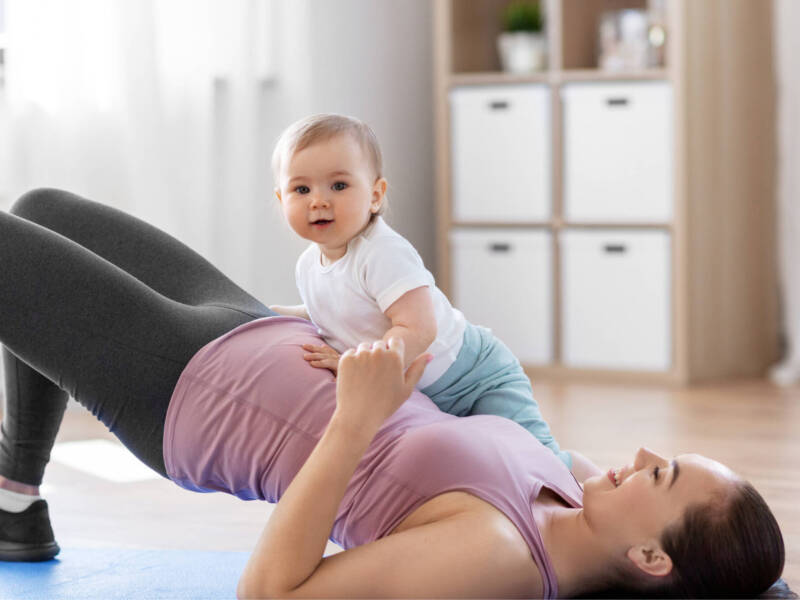 woman doing a bridge with a baby