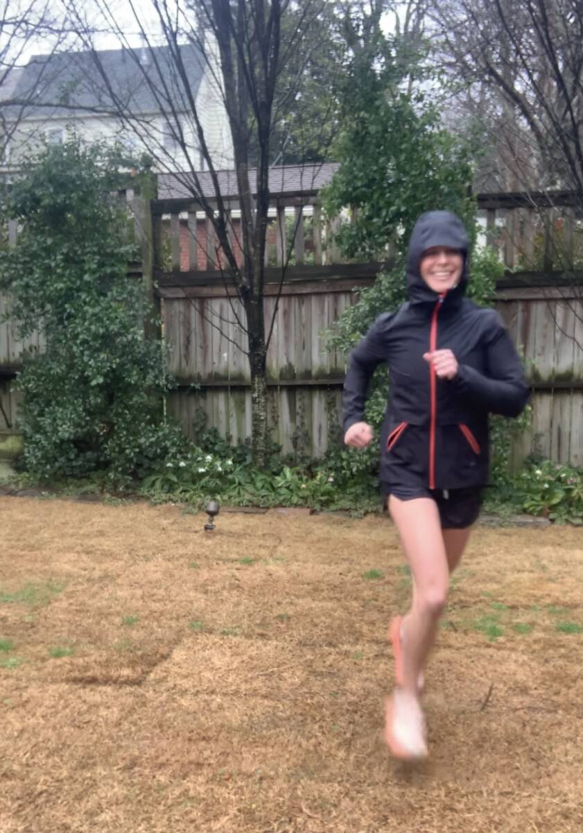 whitney running in black rain jacket