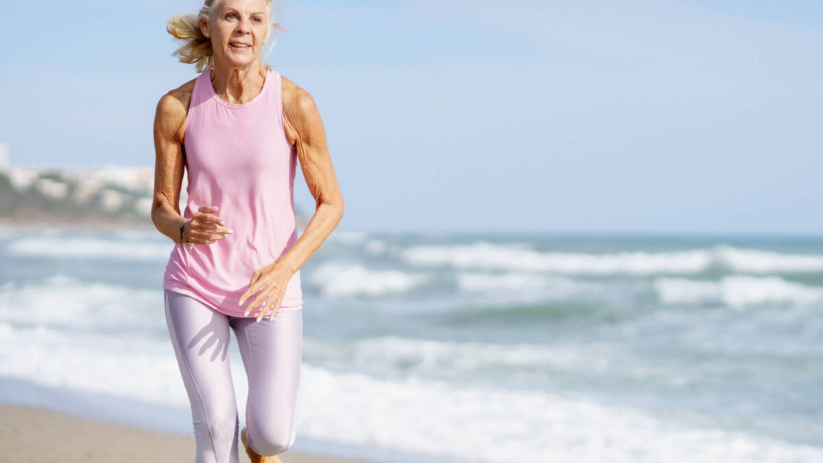 older woman running on the beach