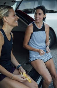 women eating on tailgate of car