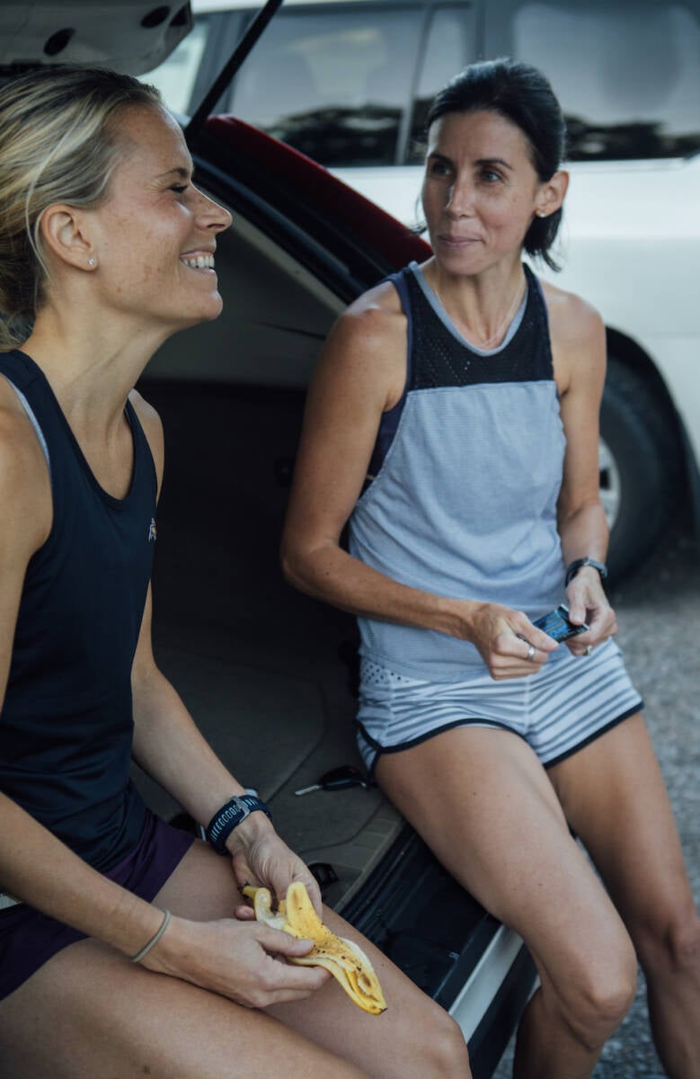 women eating on tailgate of car