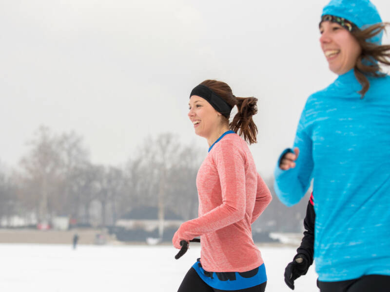 two women running in the snow