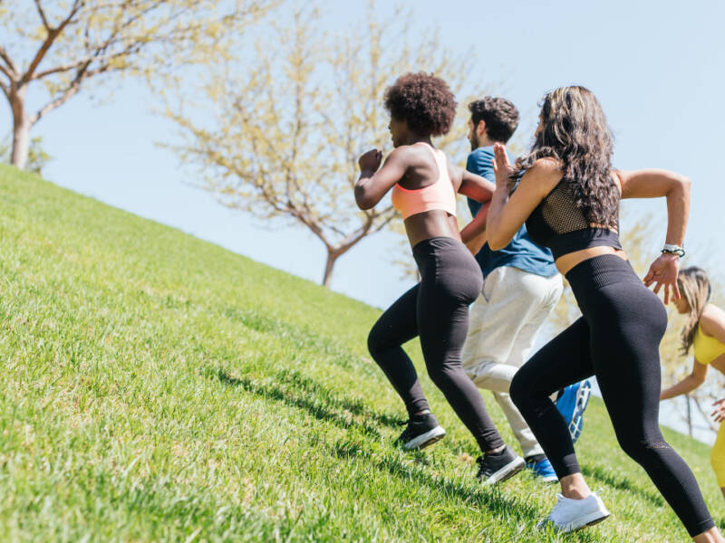 women running a grassy hill