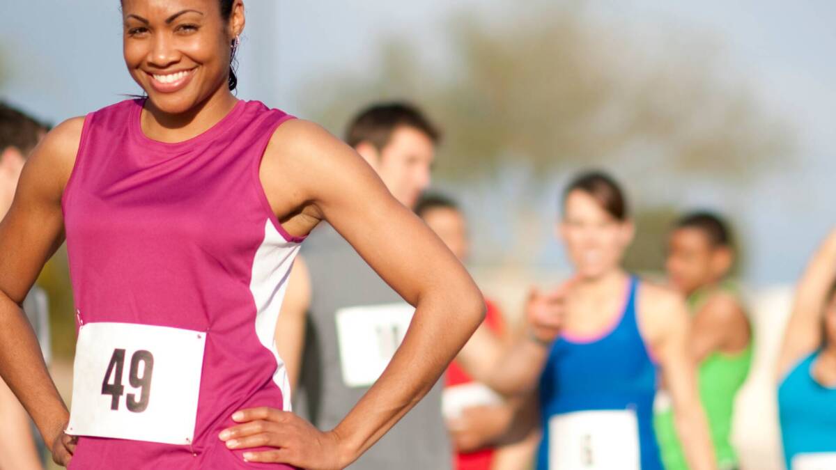 women runner in pin with race bib smiling