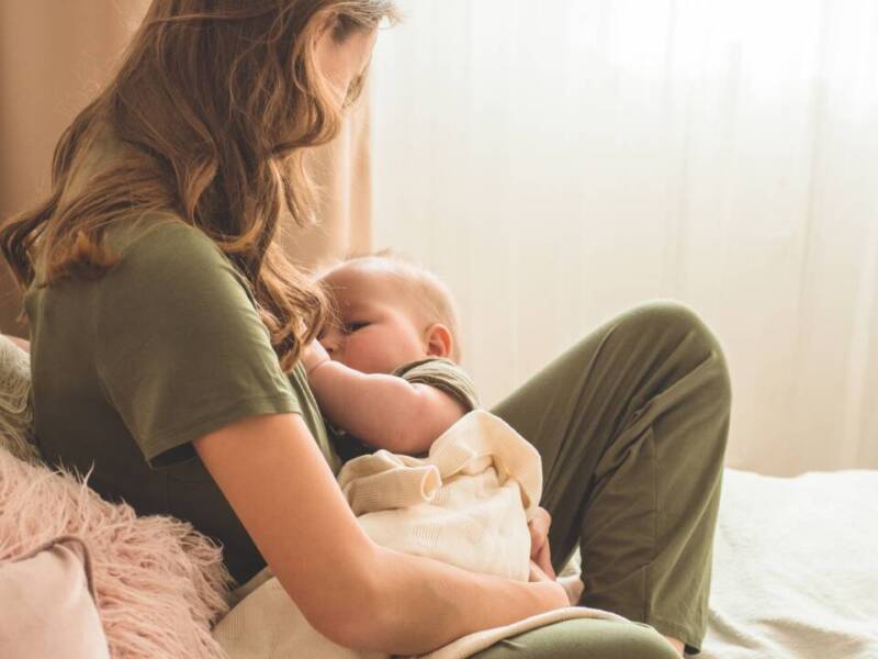 breastfeeding mom in chair with baby