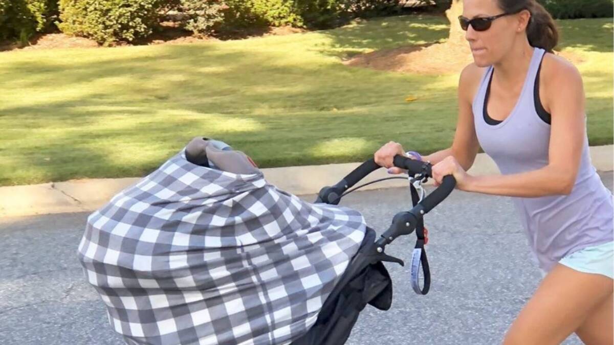 Woman running hard with a jogging stroller.