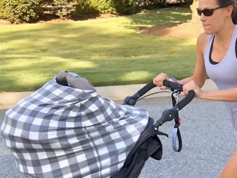 Woman running hard with a jogging stroller.