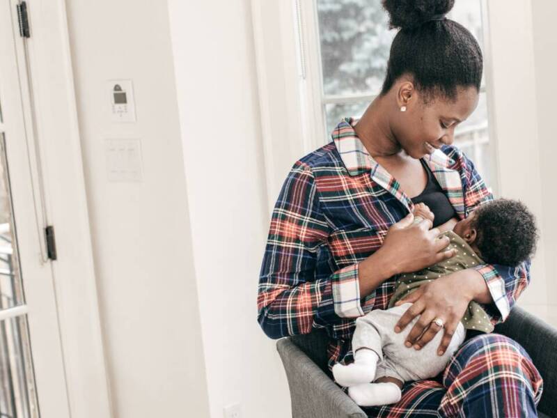 woman breastfeeding baby in flannel robe