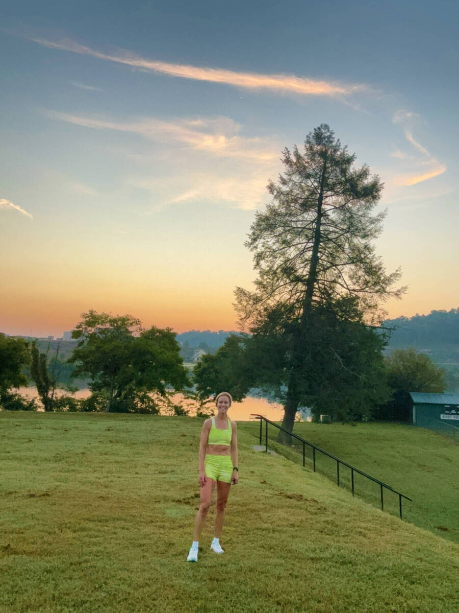 Whitney Heins in lime green running outfit in field